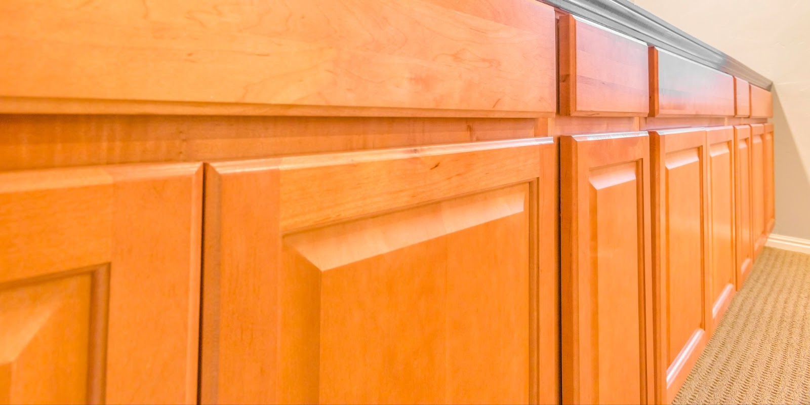Close-up of wooden kitchen cabinets with a dark staining, enhancing the warmth of the kitchen