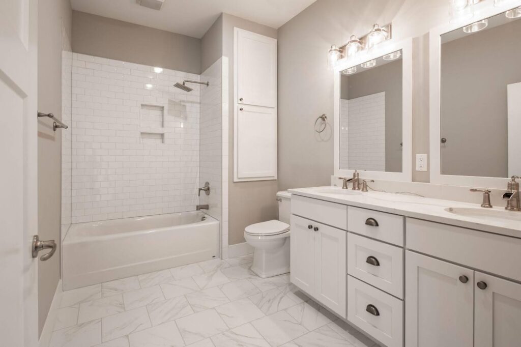 A clean bathroom featuring white cabinets and a polished tile floor creating a bright and spacious atmosphere