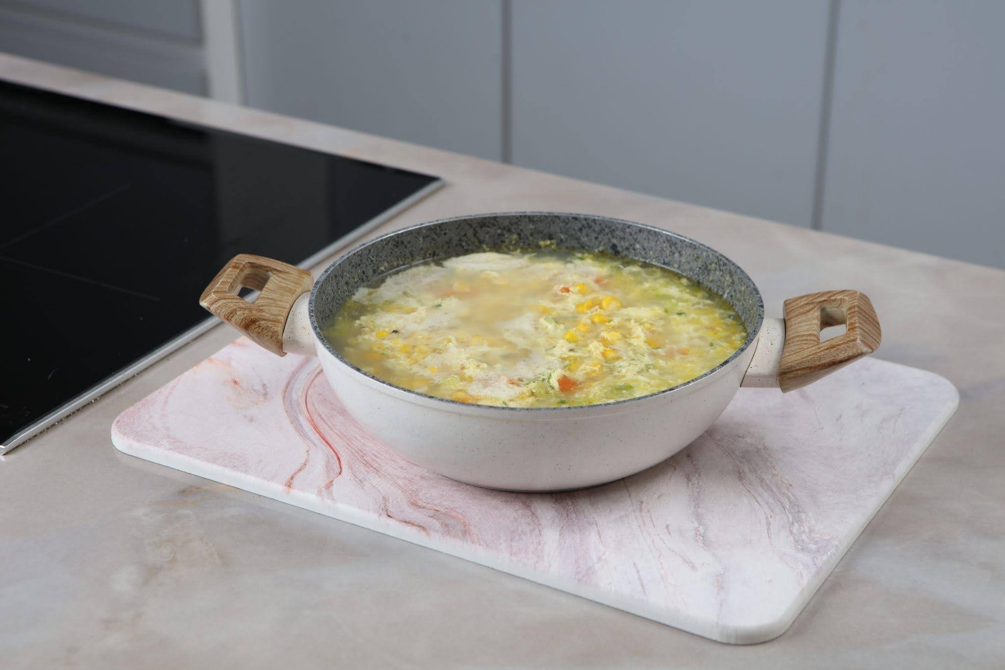 A bowl of soup placed on a polished marble counter showcasing its rich color and texture