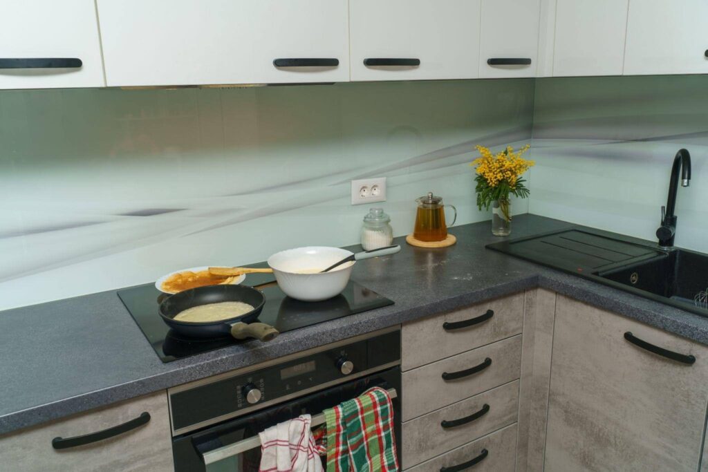 A kitchen with a stove and neatly arranged pots and pans on the counter showcasing a cooking space