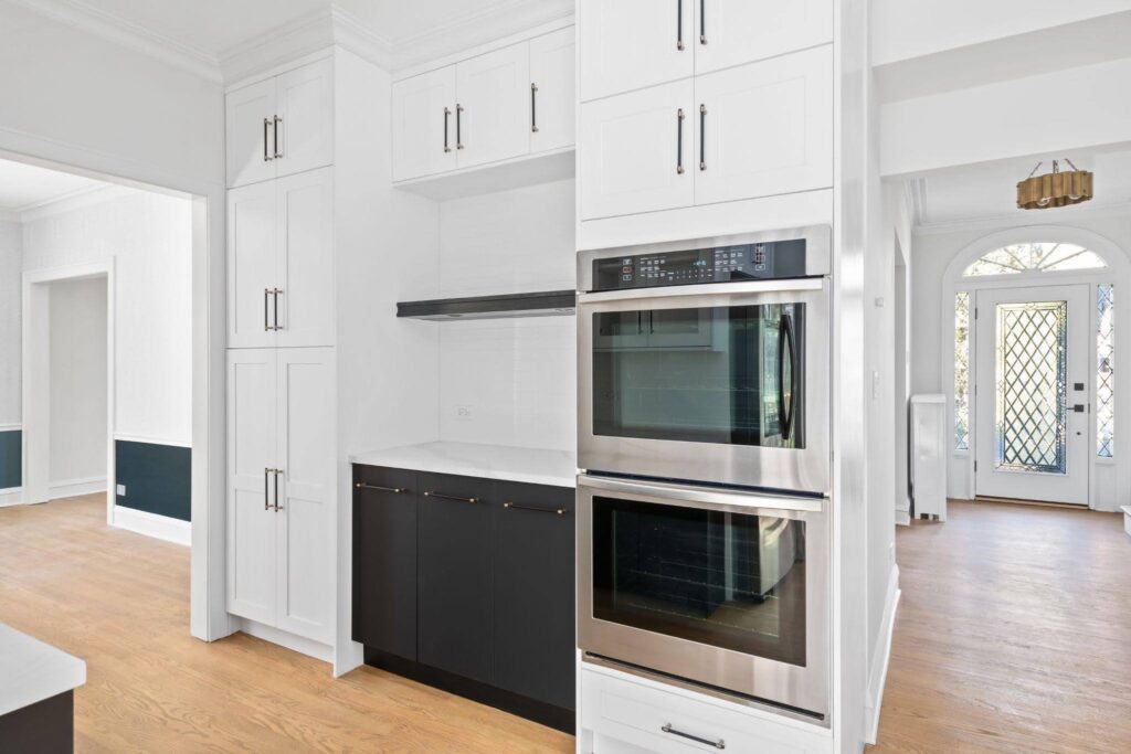 A modern kitchen featuring white cabinets and a sleek stainless steel oven