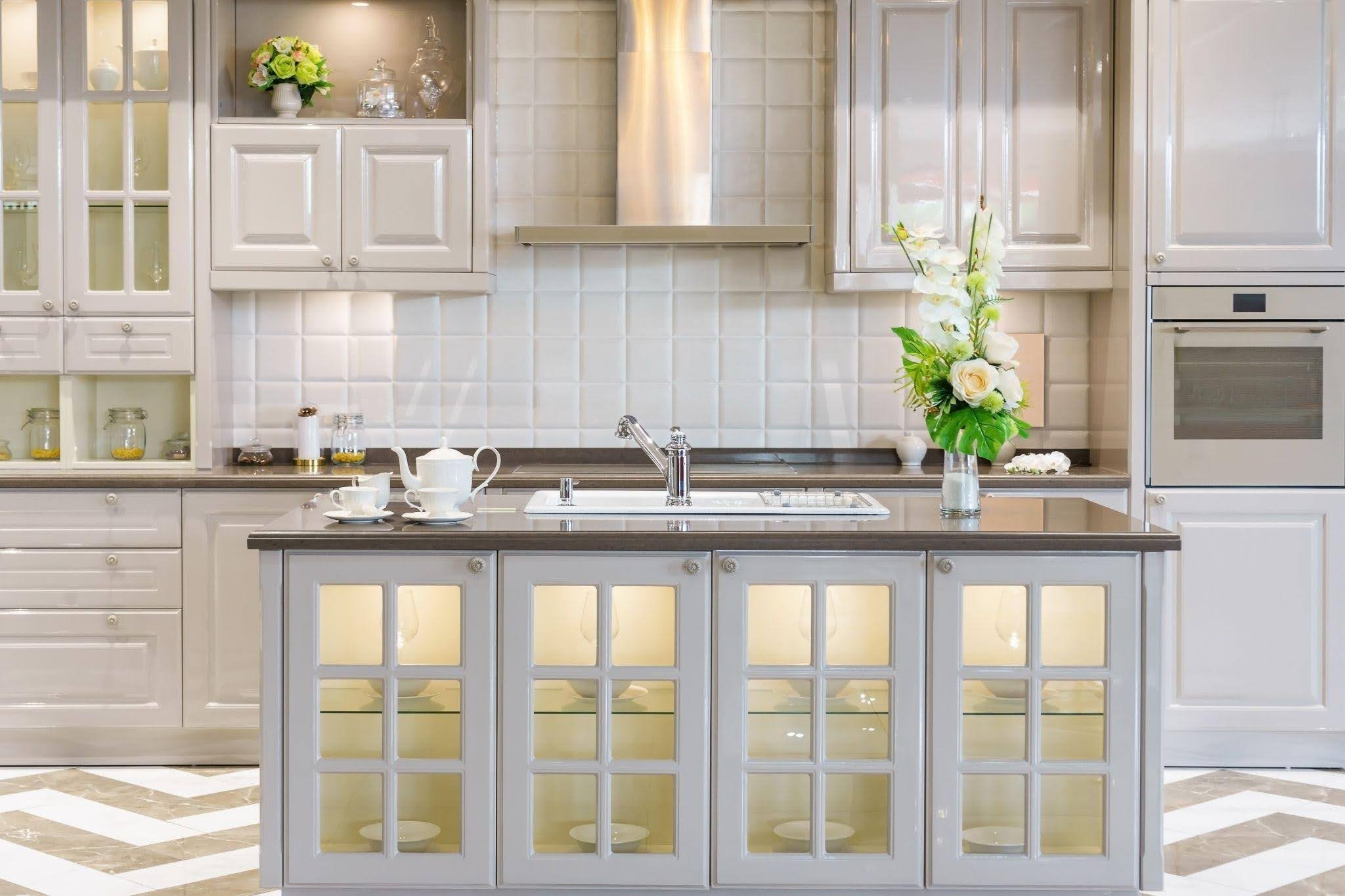 Bright kitchen featuring white cabinetry and a chevron patterned wall