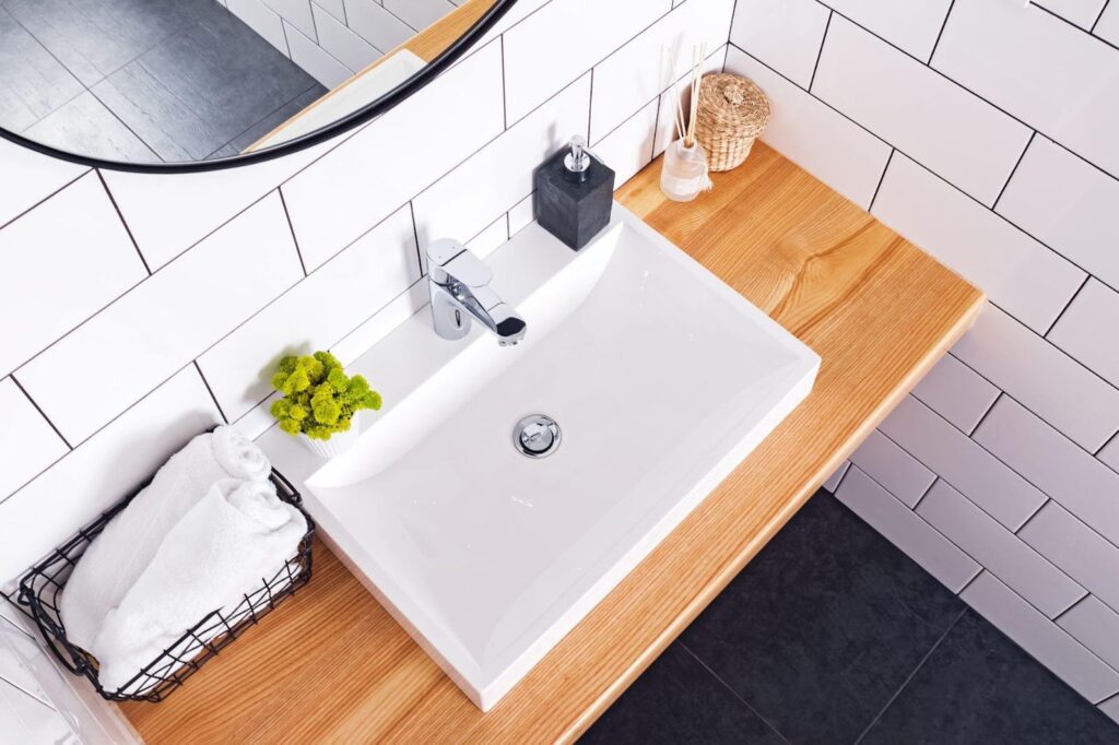 A bathroom featuring a sink and a mirror above it with neutral-colored walls and a clean modern design