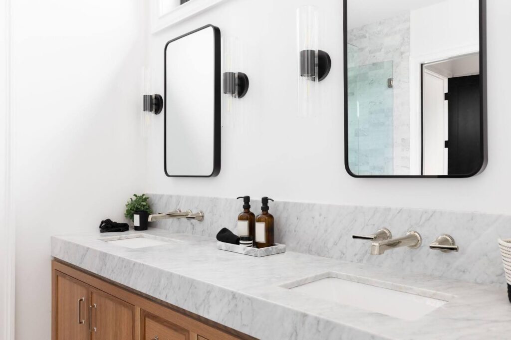 A stylish modern bathroom showcasing two mirrors above a chic sink with minimalist design elements