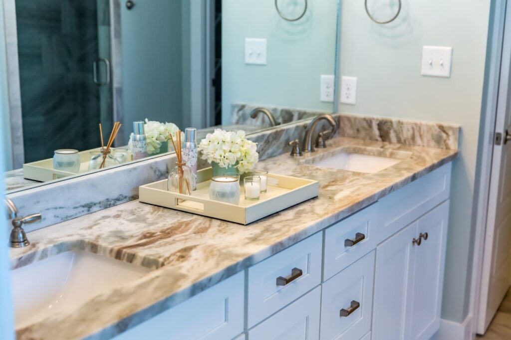 A modern bathroom featuring elegant marble countertops and sleek white cabinets