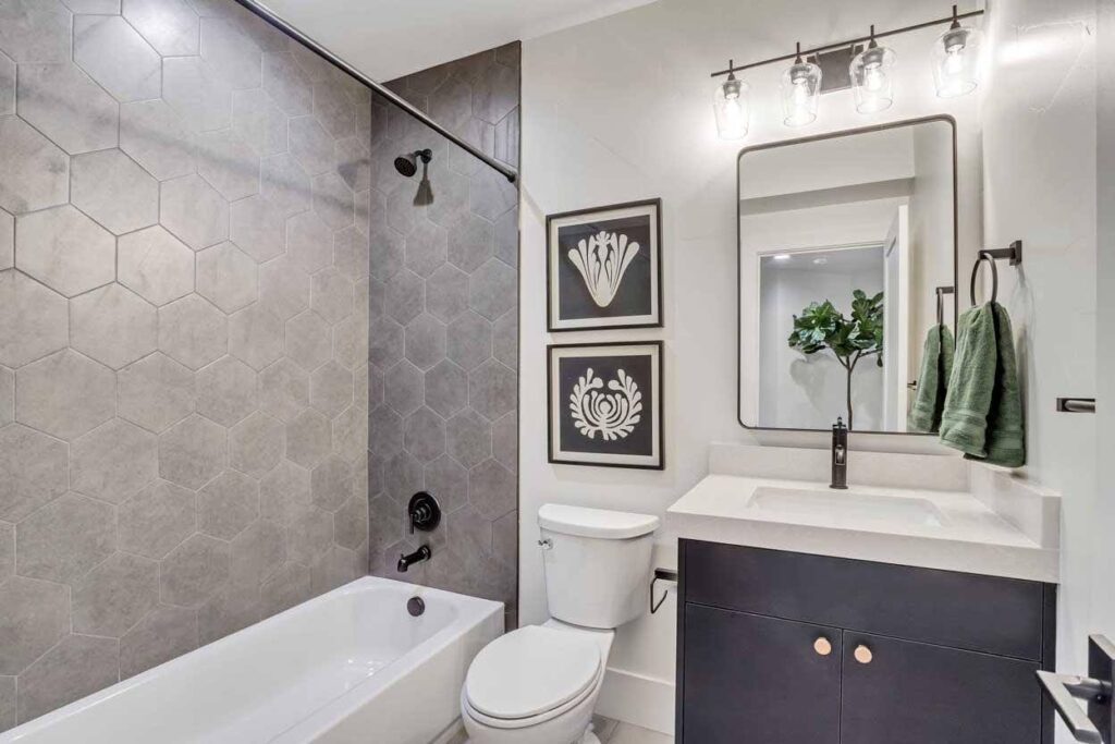 A clean bathroom featuring a white toilet and a matching sink against a neutral wall