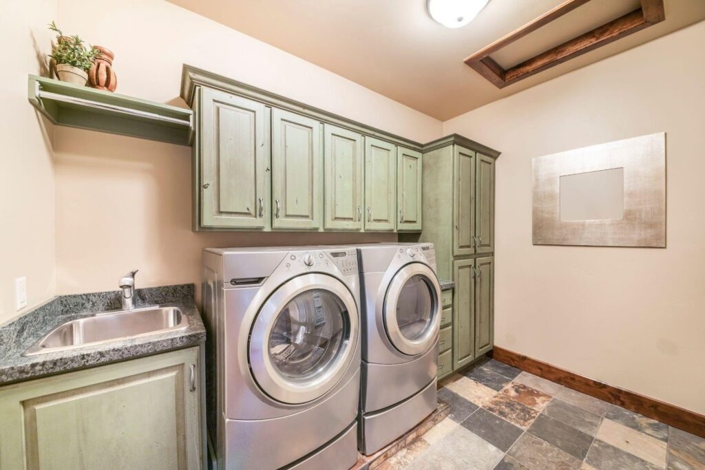 A functional laundry room with a modern washer and dryer installed complete with storage shelves above