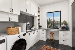 A laundry room featuring a modern washer and dryer with shelves and laundry baskets in view