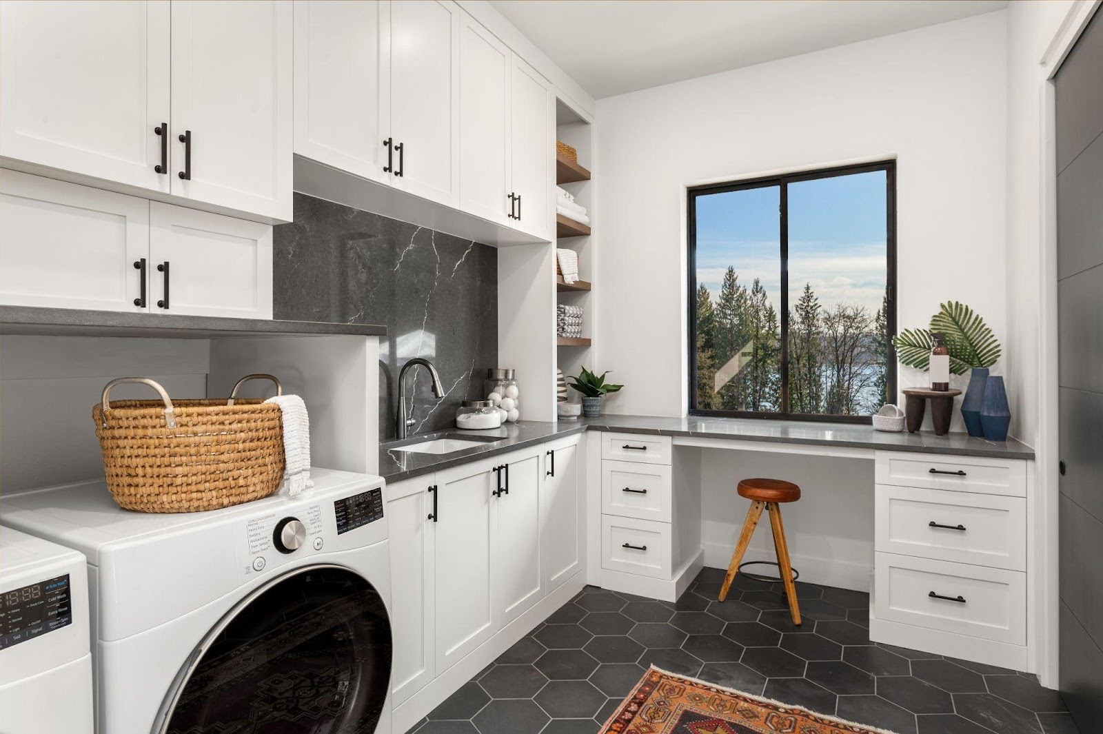 A laundry room featuring a modern washer and dryer with shelves and laundry baskets in view