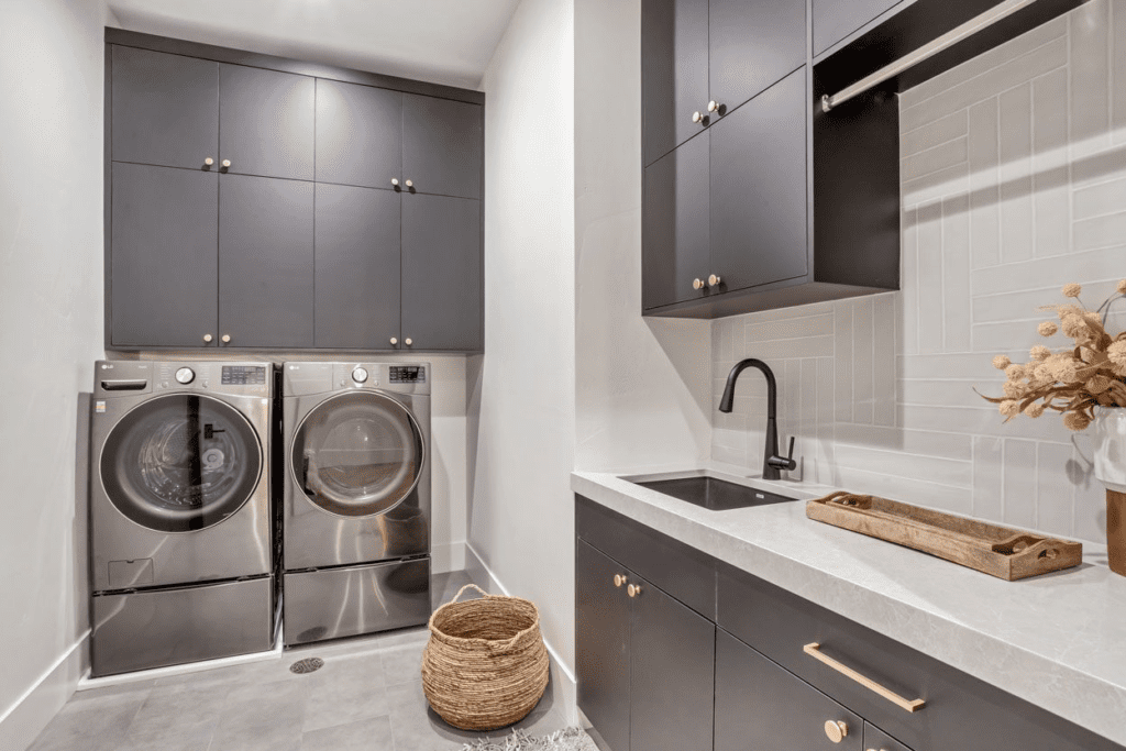 A modern laundry room featuring a sleek washer and dryer against a bright organized backdrop