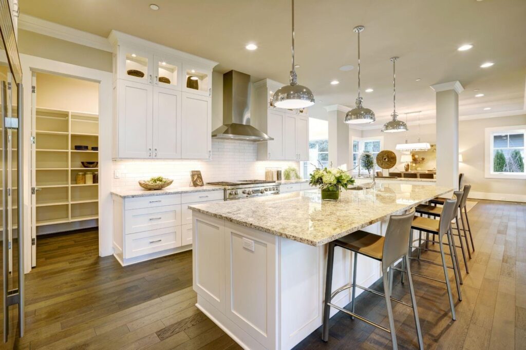 A spacious kitchen featuring white cabinets and a central island designed for functionality and style