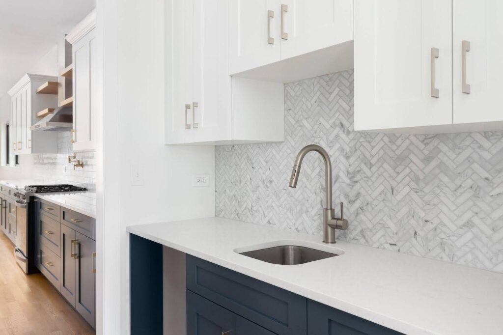 A stylish kitchen with sleek white cabinetry and vibrant blue countertops