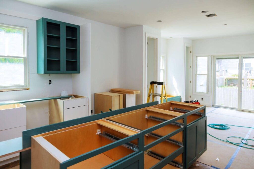A kitchen under construction featuring cabinets and countertops being installed