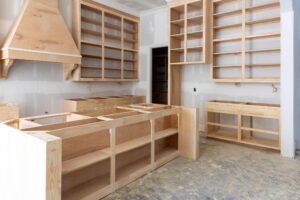 A kitchen under construction featuring cabinets and shelves being assembled