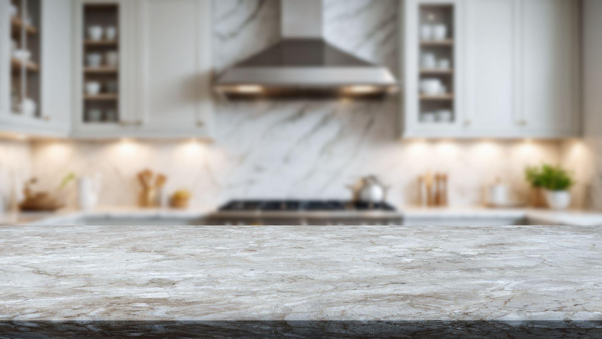 A kitchen counter with a sleek marble top and white cabinets reflecting modern design