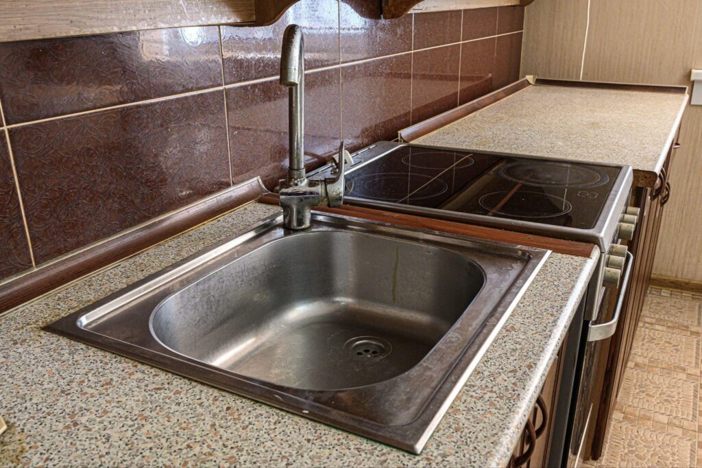 A kitchen featuring a sink and a stove top showcasing a clean and organized cooking space